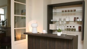 Una recepción de diseño moderno, una planta en maceta y una estantería con diversos objetos.