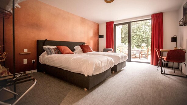 Habitación de hotel moderna con una cama grande, un escritorio y vistas al exterior.