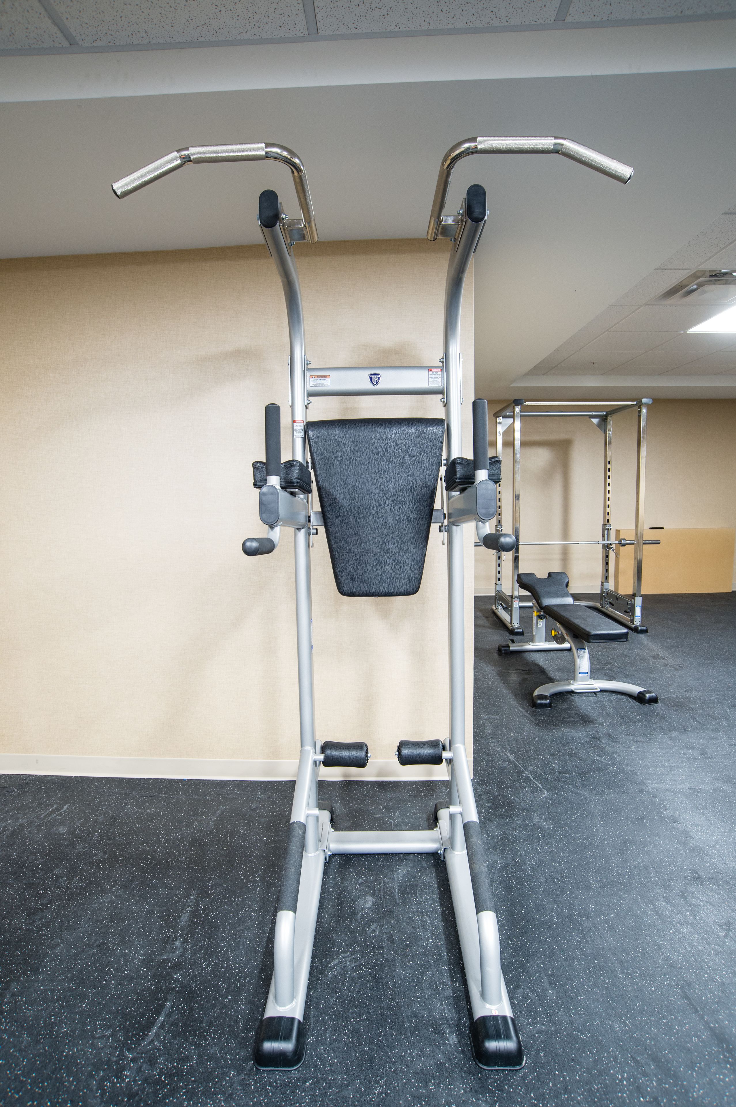 A gym with exercise equipment, including a bench press and a squat rack.