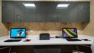 A desk with two monitors, a printer, and a keyboard.