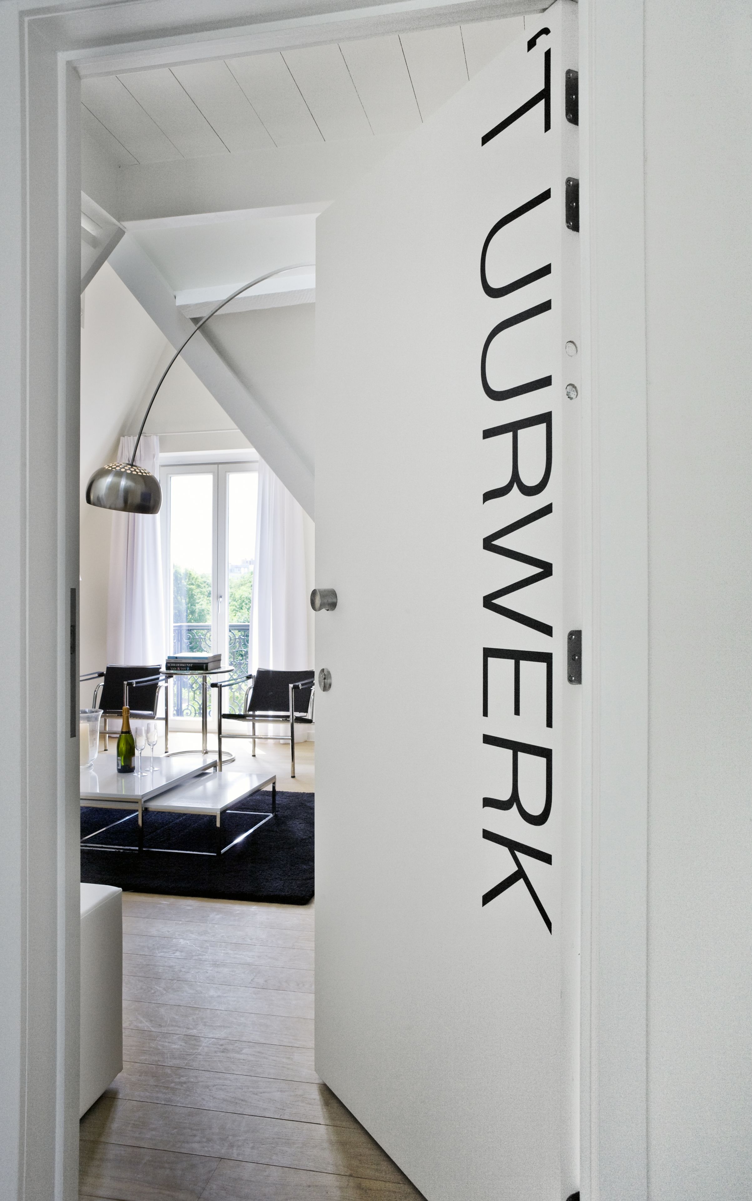 A hallway with a white door labeled "STURWERK".
