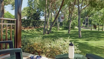 An outdoor seating area with a table, chairs, a water bottle, and a pair of shoes.