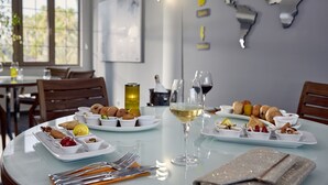 Una mesa de comedor con platos de comida, copas de vino y cubiertos.