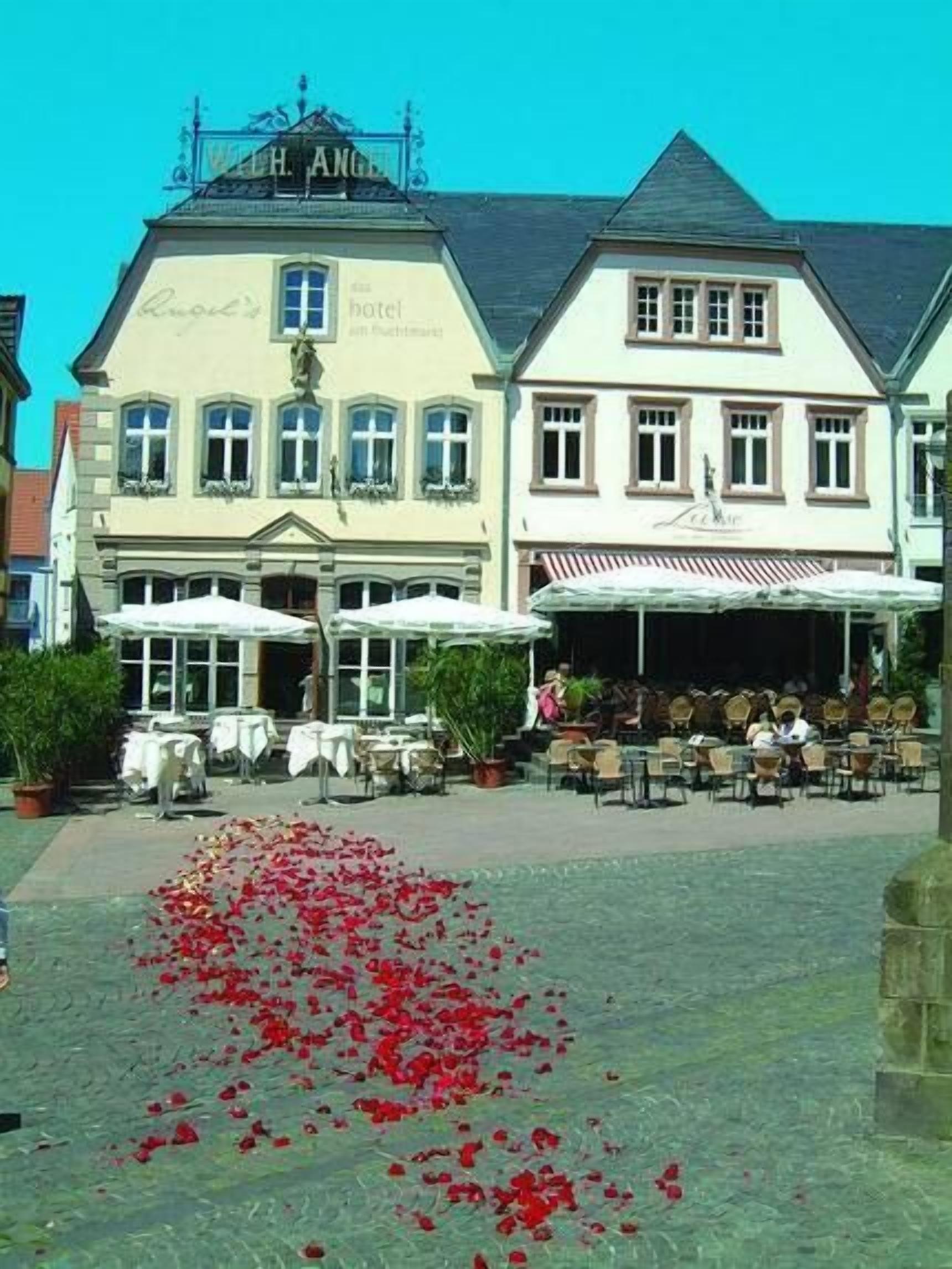 A hotel with outdoor seating and a flower arrangement on the ground.