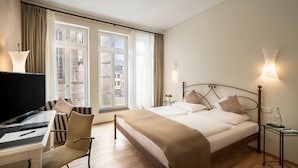Une chambre d’hôtel équipée d’un lit, d’un bureau avec un ordinateur, d’une chaise et d’un téléviseur.