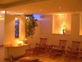 Una habitación acogedora con zona de estar, una mesita con velas y una ventana con planta.