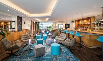 Un espacio lounge moderno con asientos cómodos, un bar y vistas al exterior.