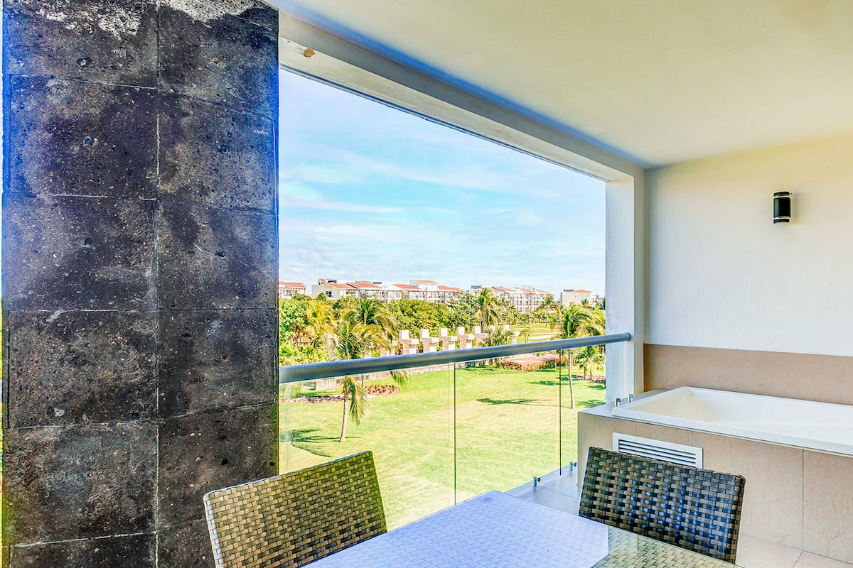 Ein Balkon mit Blick auf eine Wohngegend, ein weißes Waschbecken und ein Tisch mit Stühlen.