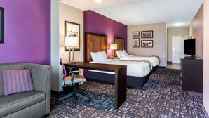 A hotel room with a bed, desk, chair, and a television. - La Quinta Inn & Suites by Wyndham Monahans (Monahans)