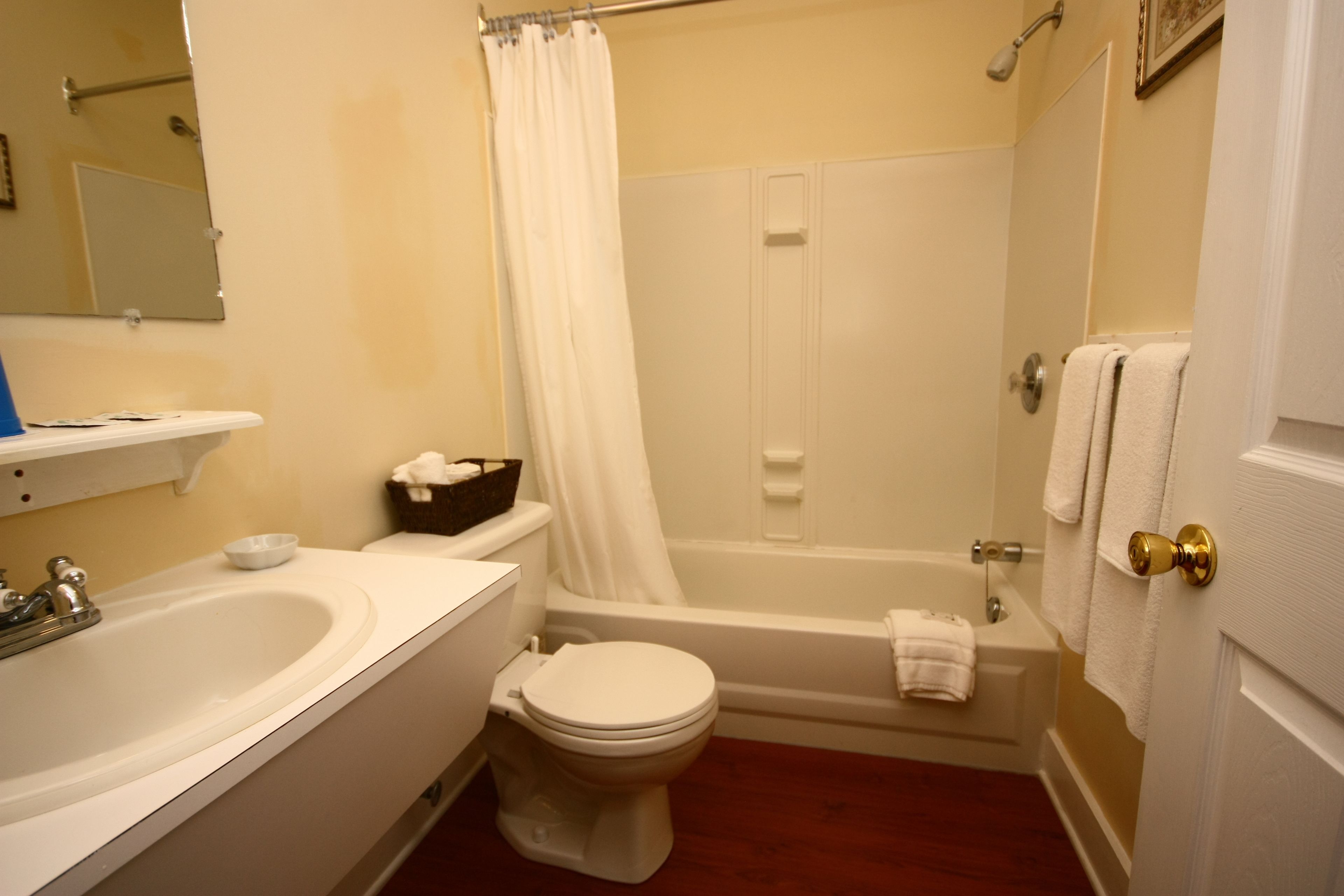 A bathroom with a sink, toilet, bathtub, and shower curtain.