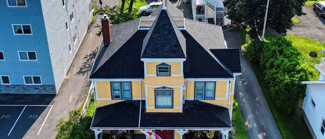Una casa de dos pisos con techo oscuro, una bandera canadiense y un césped cuidado.