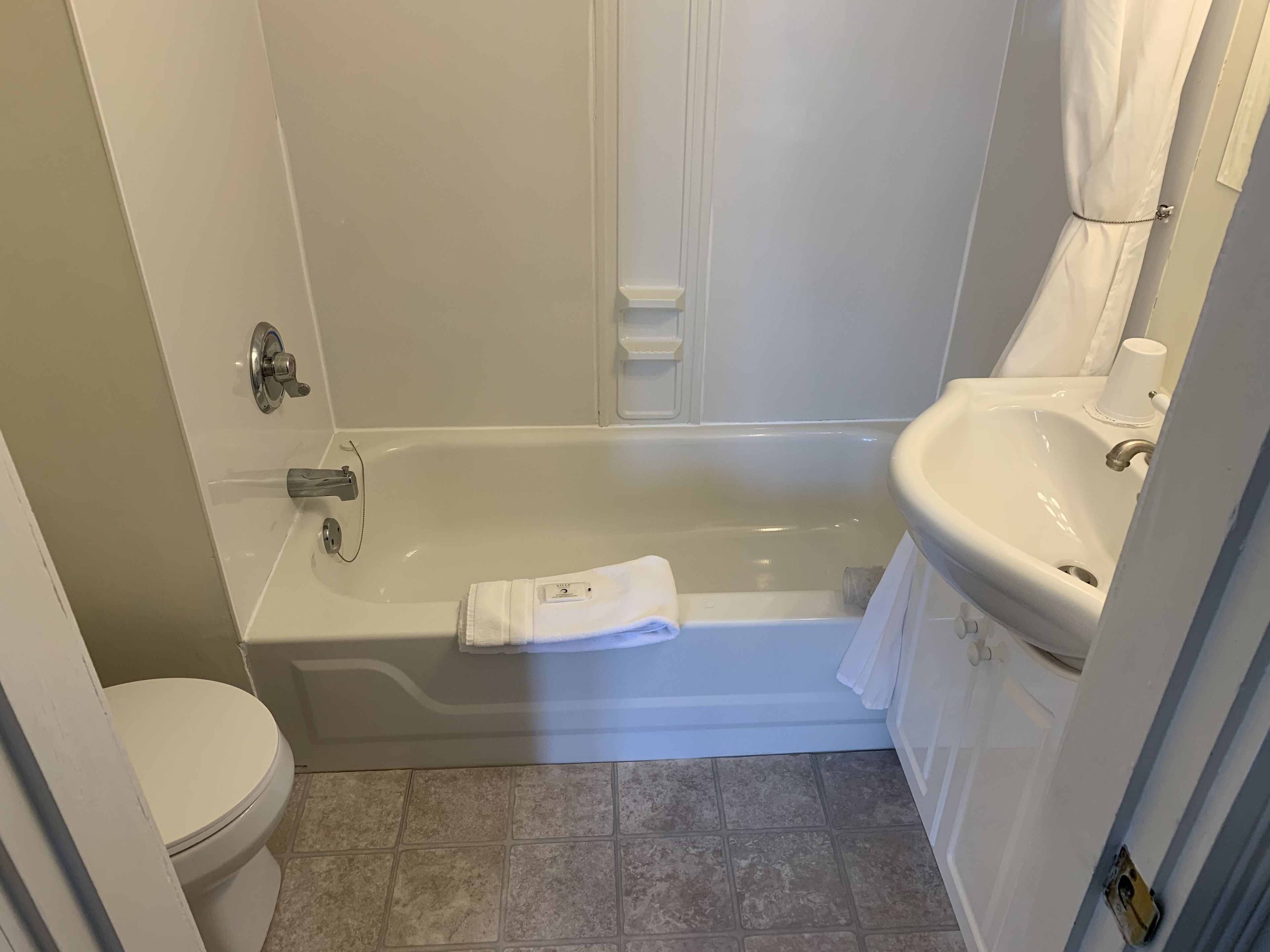 A bathroom with a bathtub, toilet, and sink.