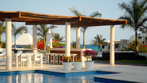 A pool area with a pergola, lounge chairs, and potted plants. - MAGIA by Stella Rentals (Playa del Carmen)