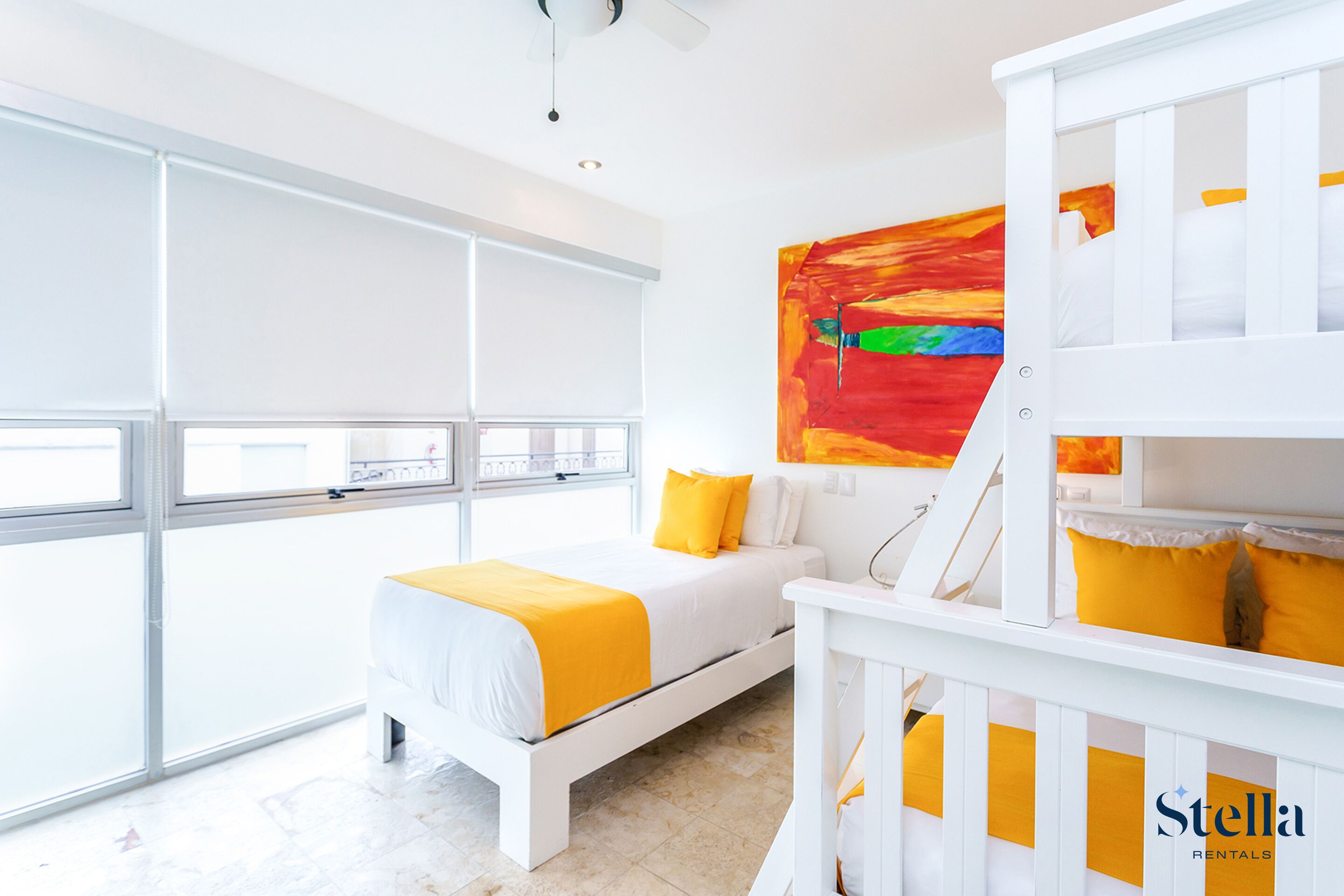 Una camera luminosa con un letto, una culla e un'ampia finestra.