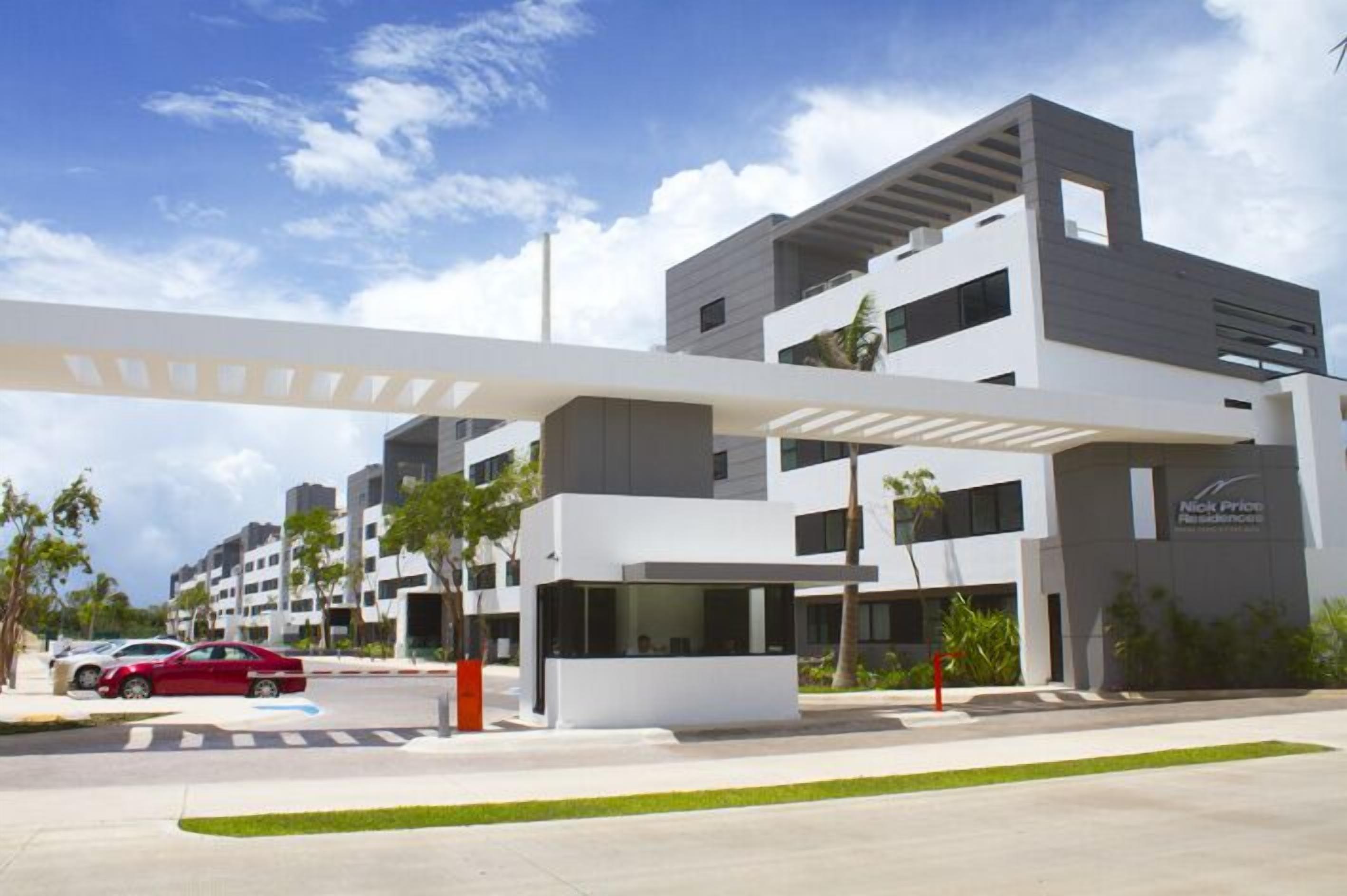 En moderne bygning med fladt tag, store vinduer og et skilt for Nick Price Healthcare.