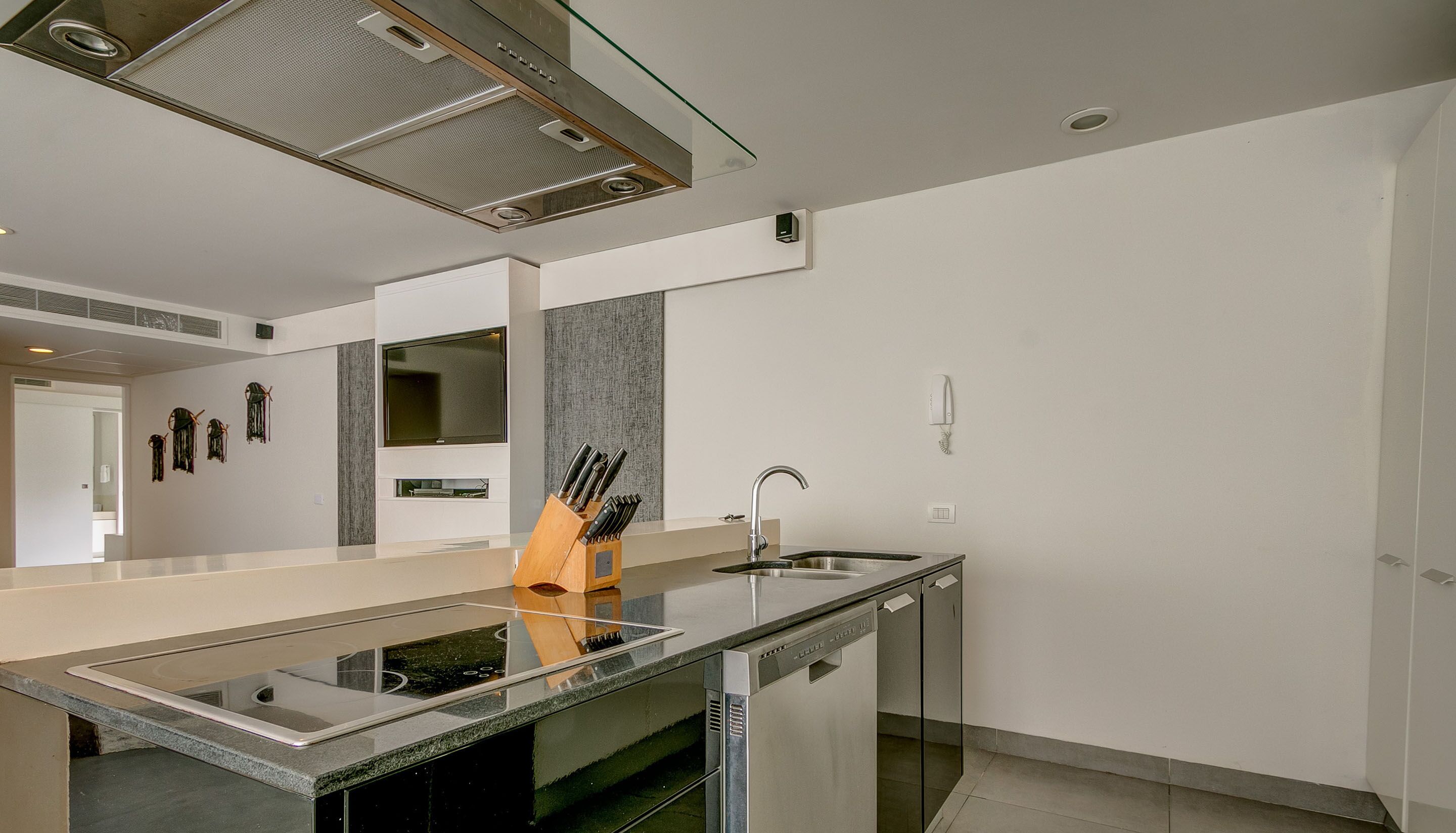 A modern kitchen with a central island, stainless steel appliances, and a built-in oven.