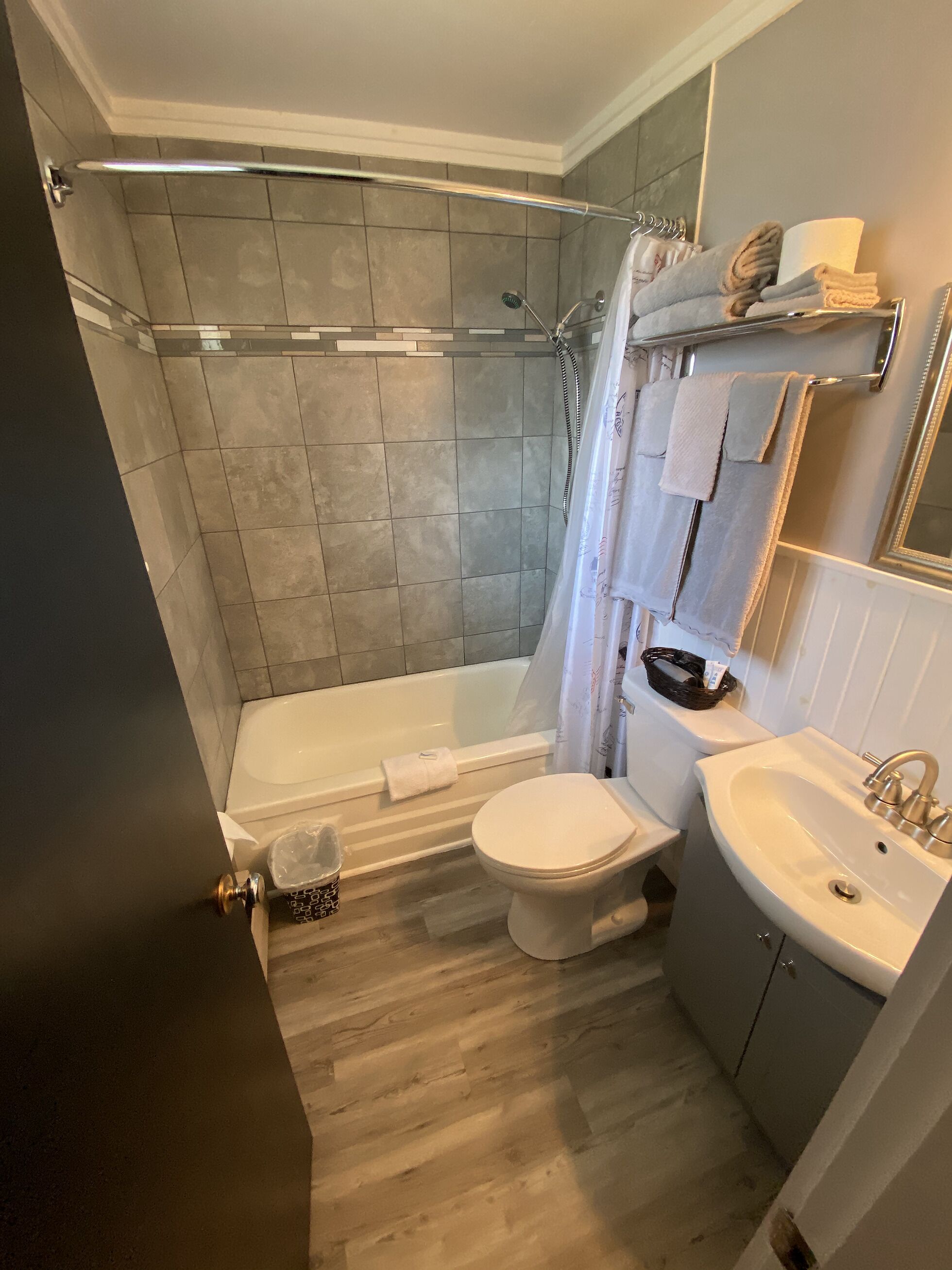 A modern bathroom with a shower, toilet, and sink.