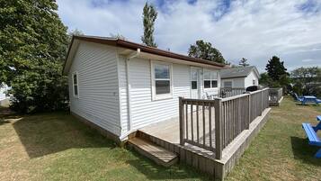 A single-story mobile home with a deck and a small porch.