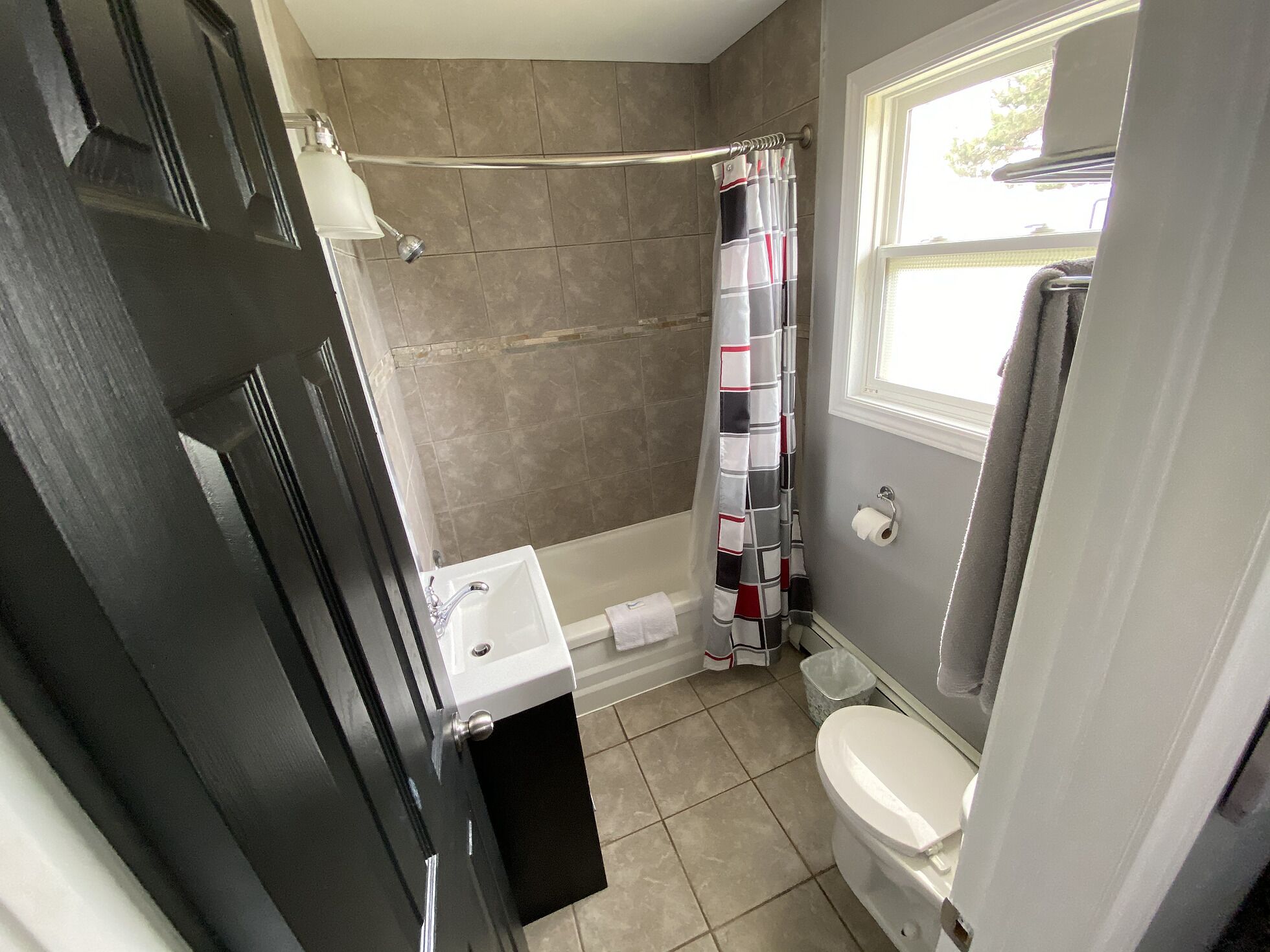 A bathroom with a bathtub, toilet, and sink.