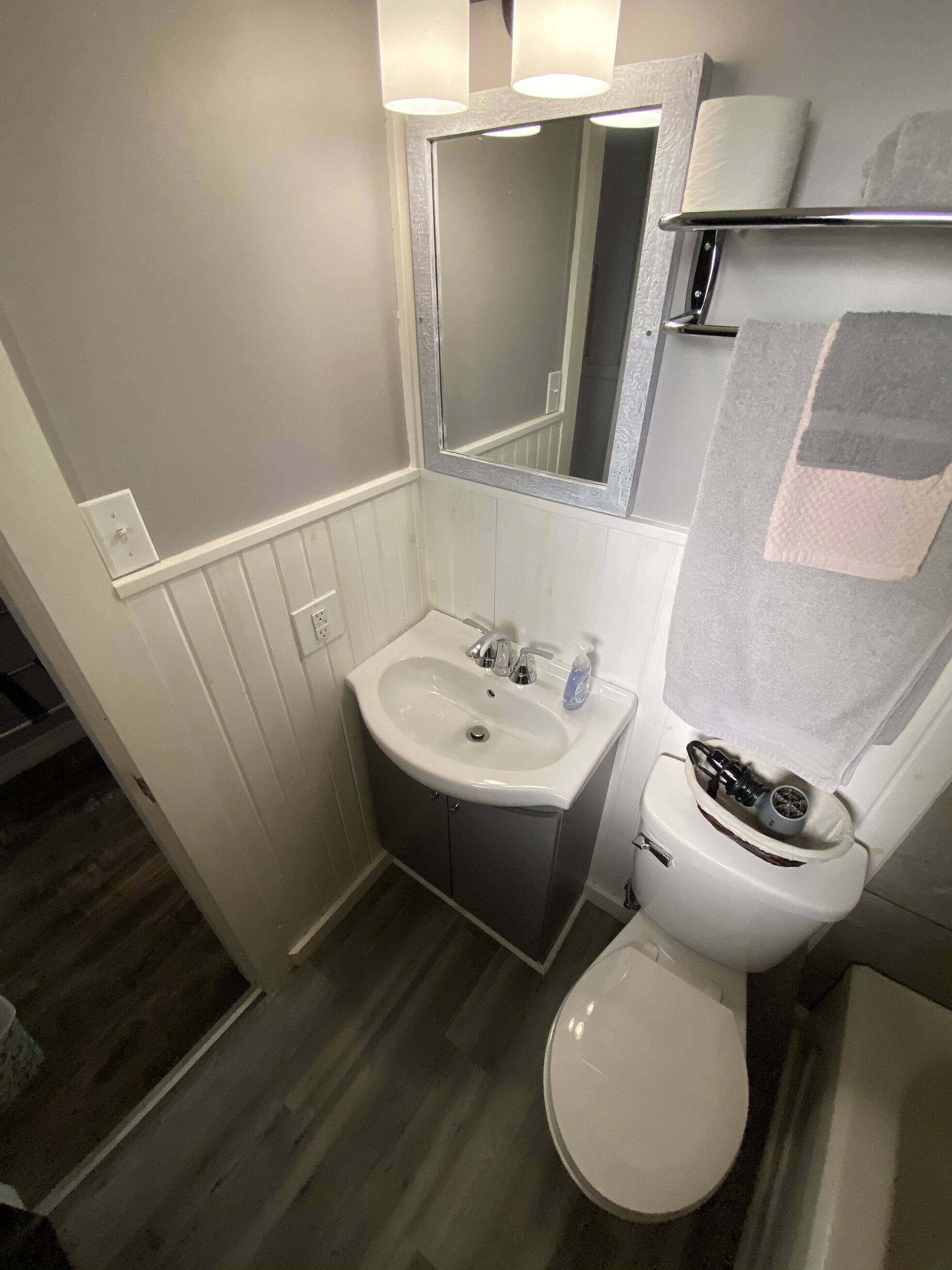 Un baño con lavamanos, espejo y retrete.