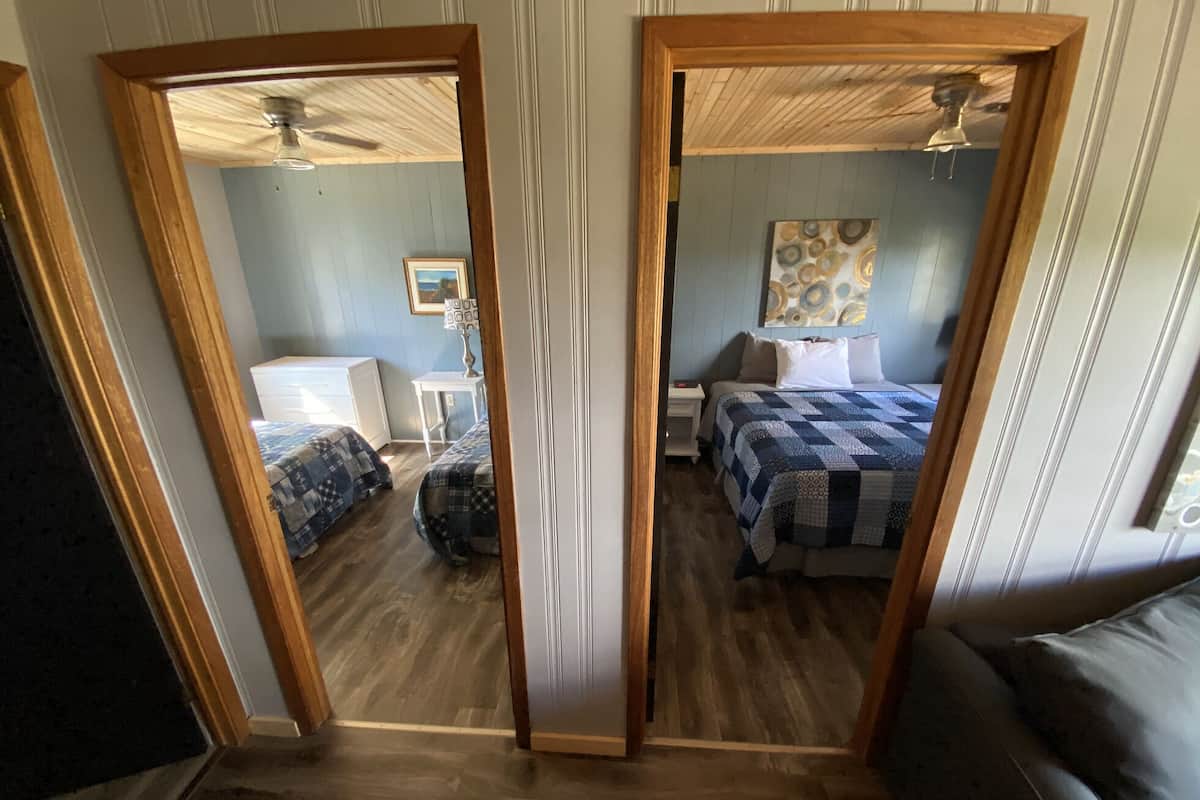 Una habitación con dos camas, un escritorio y una silla.