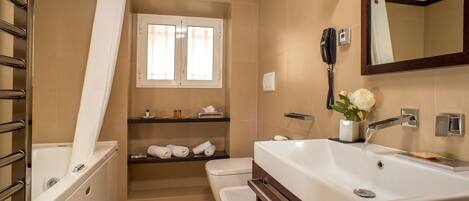 Een moderne badkamer met een bad, toilet, wastafel en spiegel.