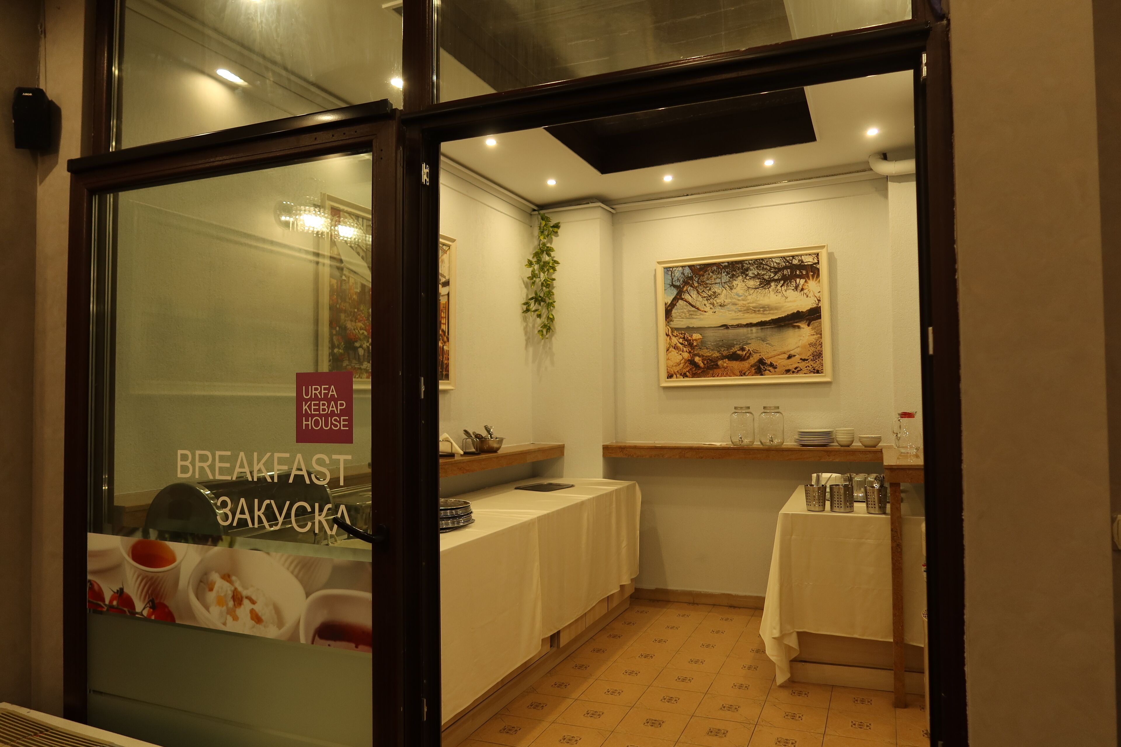 A breakfast area with a table, chairs, and a painting on the wall.
