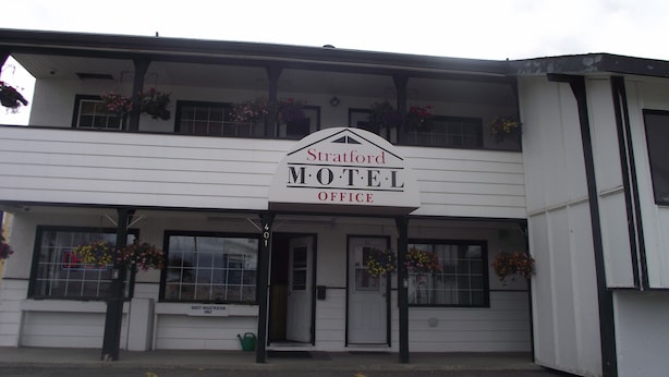 Un edificio de dos pisos con un cartel que dice 'Stratford Motel Office'.