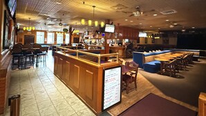 A restaurant with a bar area, booths, and a menu board. - Northern Motor Inn (Terrace)