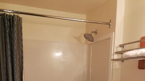 A bathroom with a shower, toilet, and a sink.