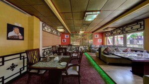 Un restaurante con decoración tradicional, que incluye muebles de madera y diseños de pared con motivos.