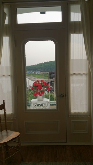 A door with a view of a green landscape and a bridge. - B&B Le Manoir du vieux Presbytère (Port-Daniel-Gascons)