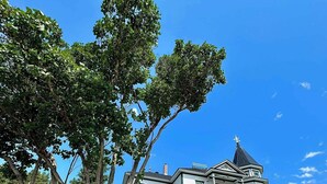 A large, two-story house with a prominent tower and a wrap-around porch. - B&B Le Manoir du vieux Presbytère (Port-Daniel-Gascons)