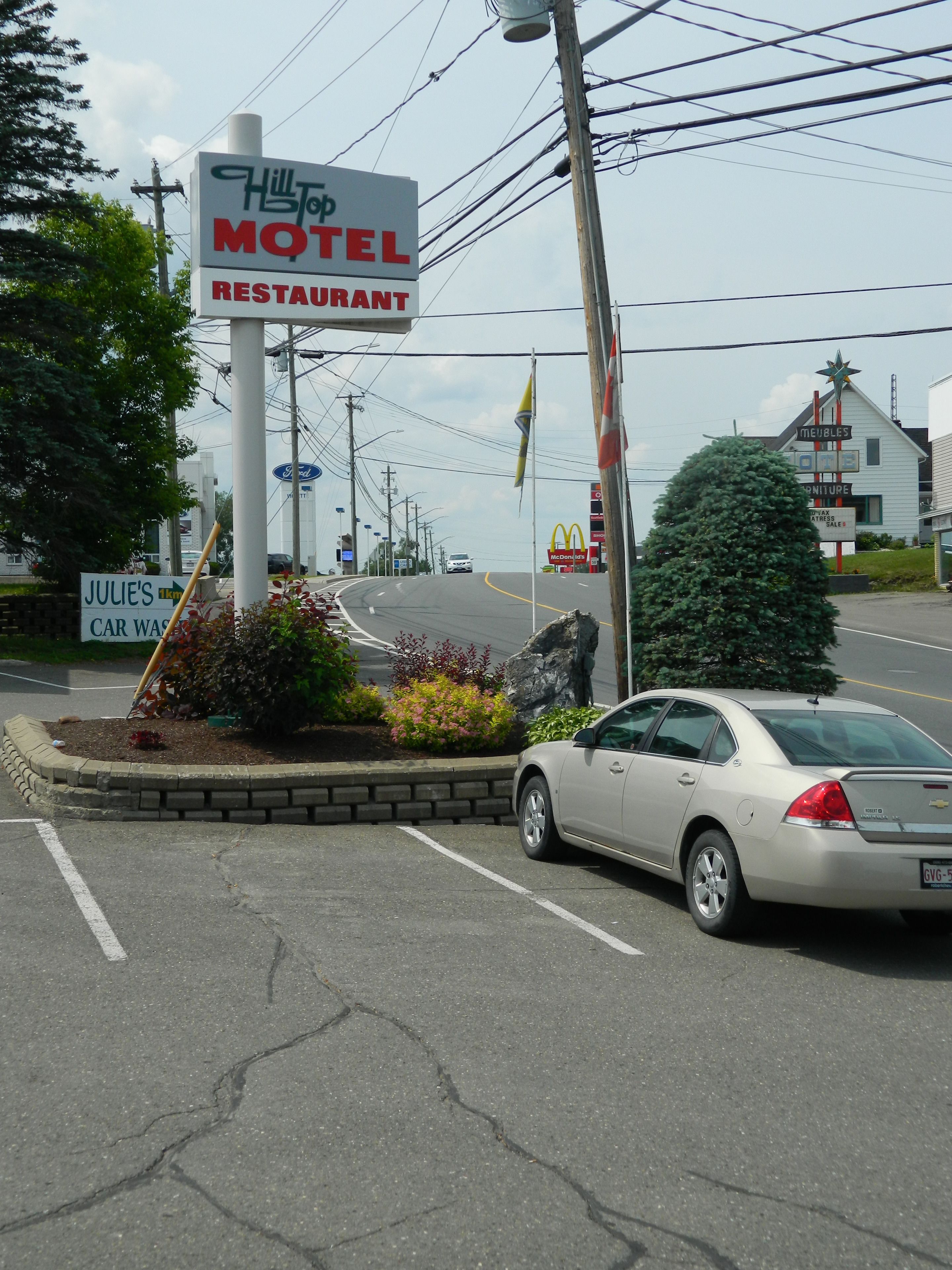A motel sign with a restaurant, a McDonald's, and a furniture store.