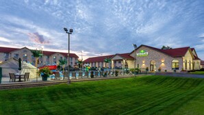 A hotel with a red roof and a sign that reads "Wingate by Wyndham". There are outdoor seating areas and a pool with lounge chairs. - Wingate by Wyndham Wisconsin Dells Waterpark (Baraboo)
