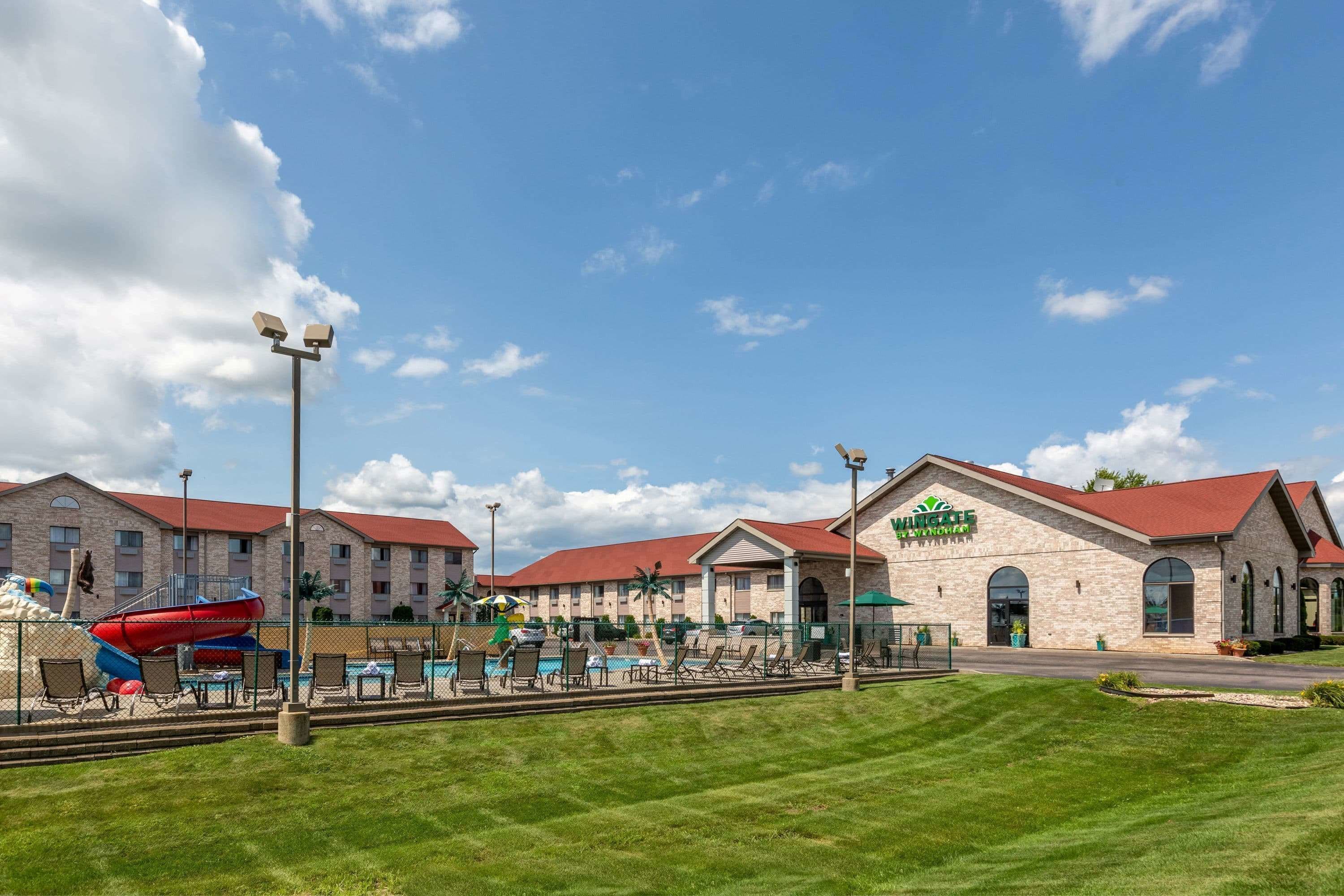 A hotel with a swimming pool, outdoor seating, and a water slide.
