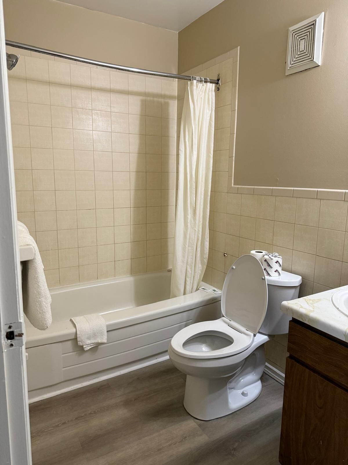 Un baño con bañera, inodoro y cortina de ducha.
