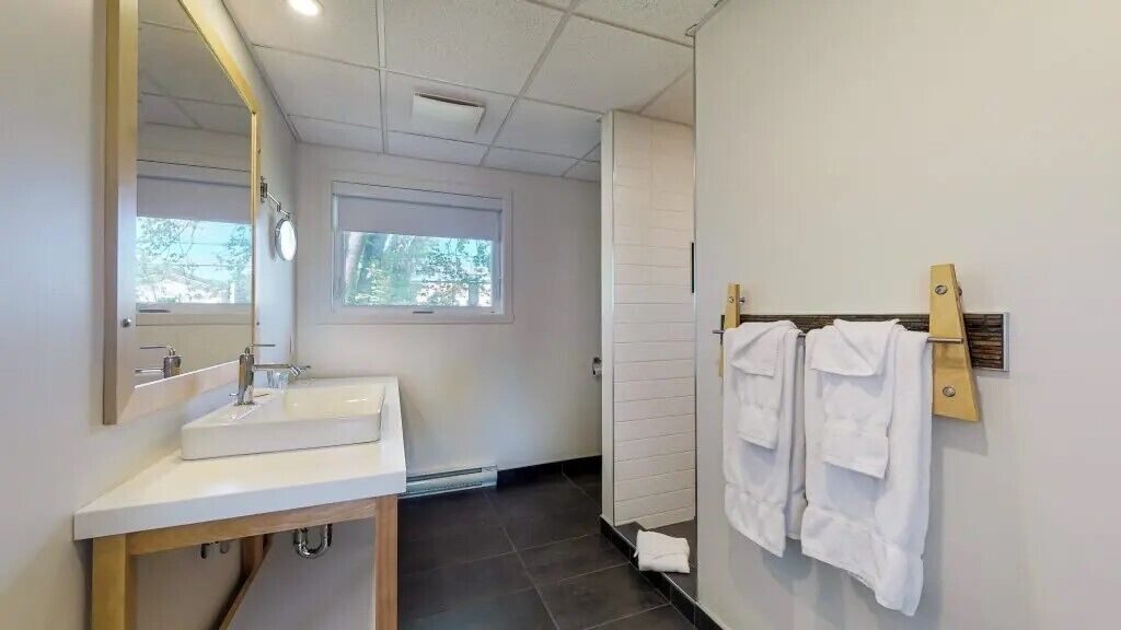 Ein modernes Badezimmer mit Waschbecken, Spiegel und Handtuchhalter.