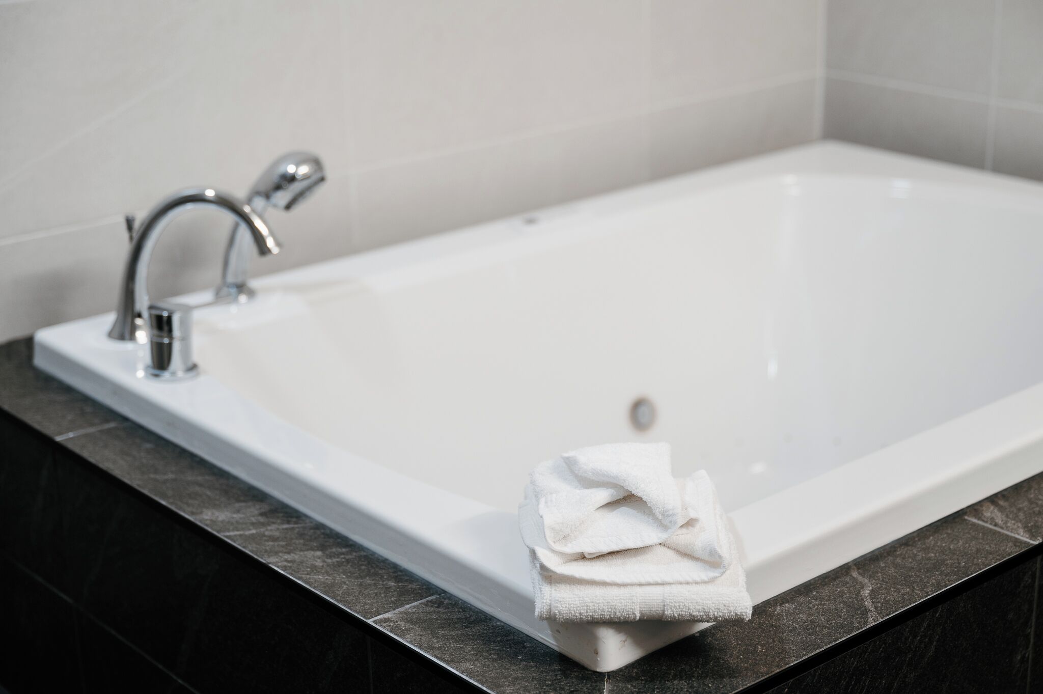 Une baignoire blanche avec une seule serviette blanche posée sur le bord.