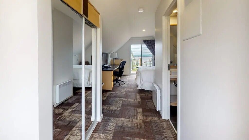 Ein Hotelzimmer mit Bett, Schreibtisch, Stuhl und Blick ins Freie.