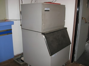 Un frigorifero compatto dallo stile industriale, con piano superiore in metallo e un'etichetta che indica il marchio 'Ice-O-Matic'.