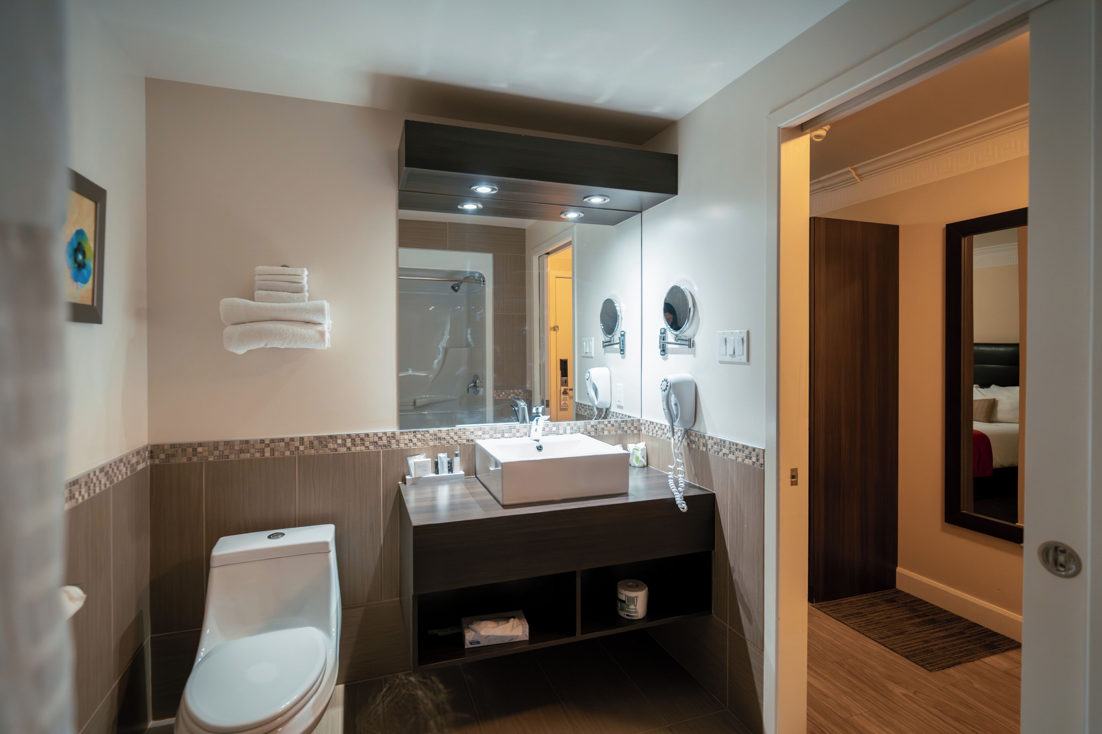A modern bathroom with a toilet, sink, and shower.
