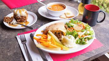 A meal with a sandwich, fries, salad, and soup on a table.