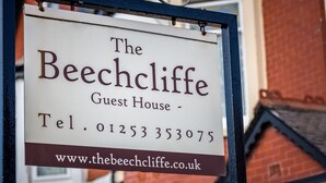 Une enseigne indiquant « The Beechcliffe Guest House », avec un numéro de téléphone et l’adresse du site web.