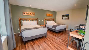 A room with two wooden beds, a desk, and a chair.
