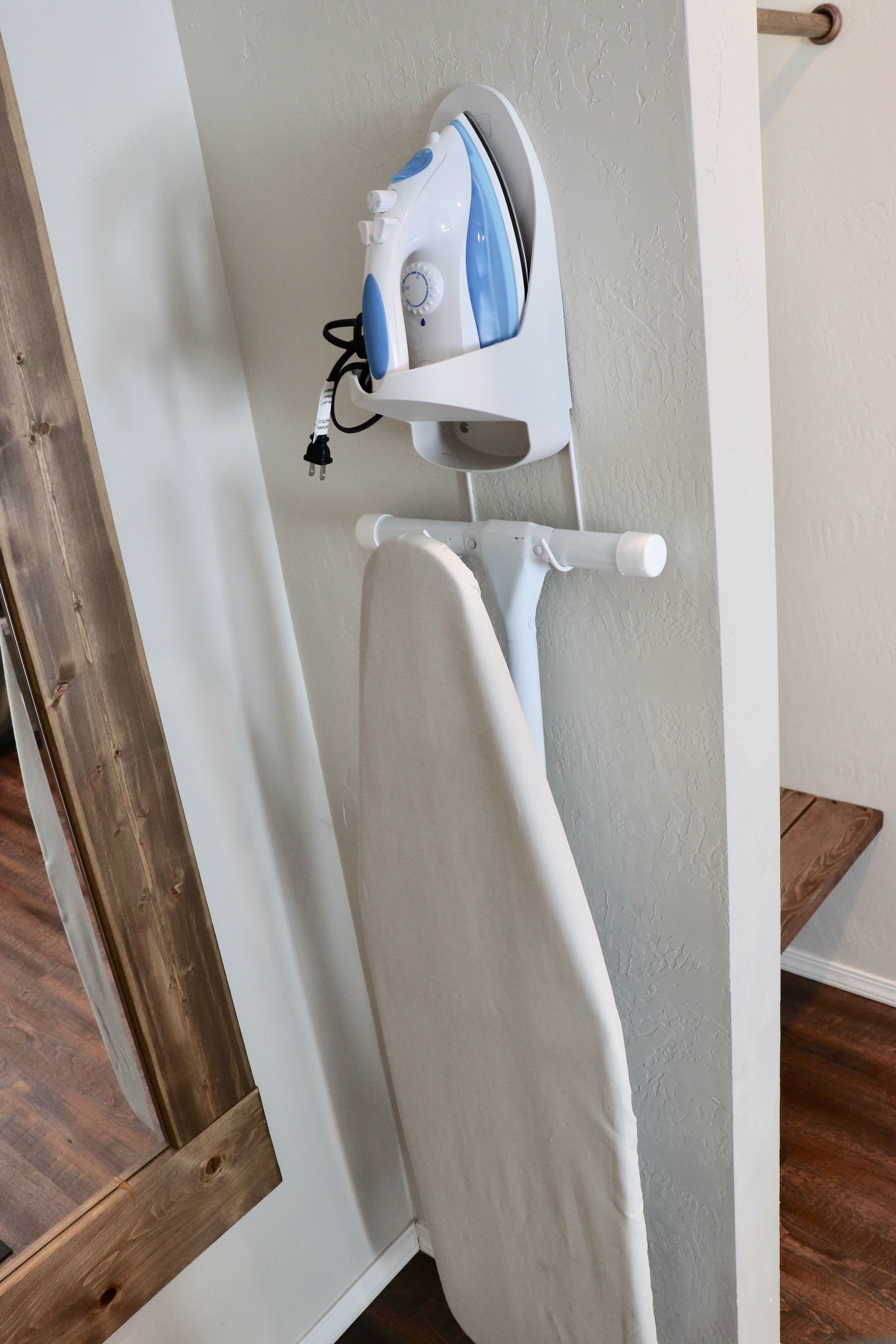 A wall-mounted ironing board with an iron.