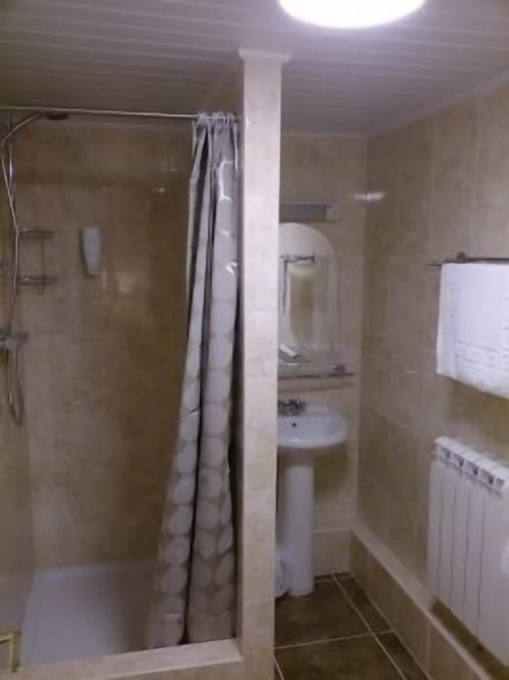 A bathroom with a shower, a sink, and a toilet.