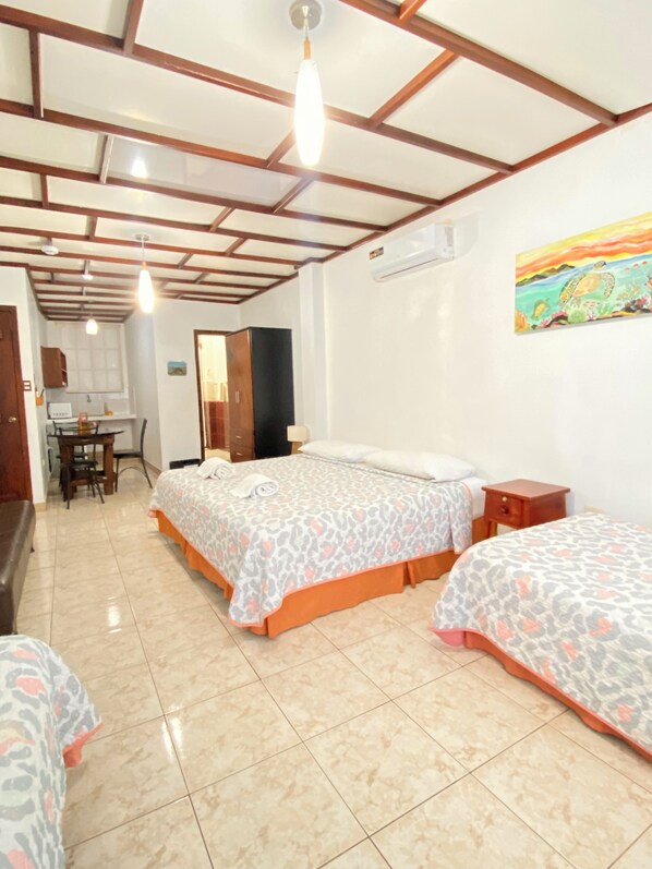 A hotel room with two beds, a desk, and a chair.