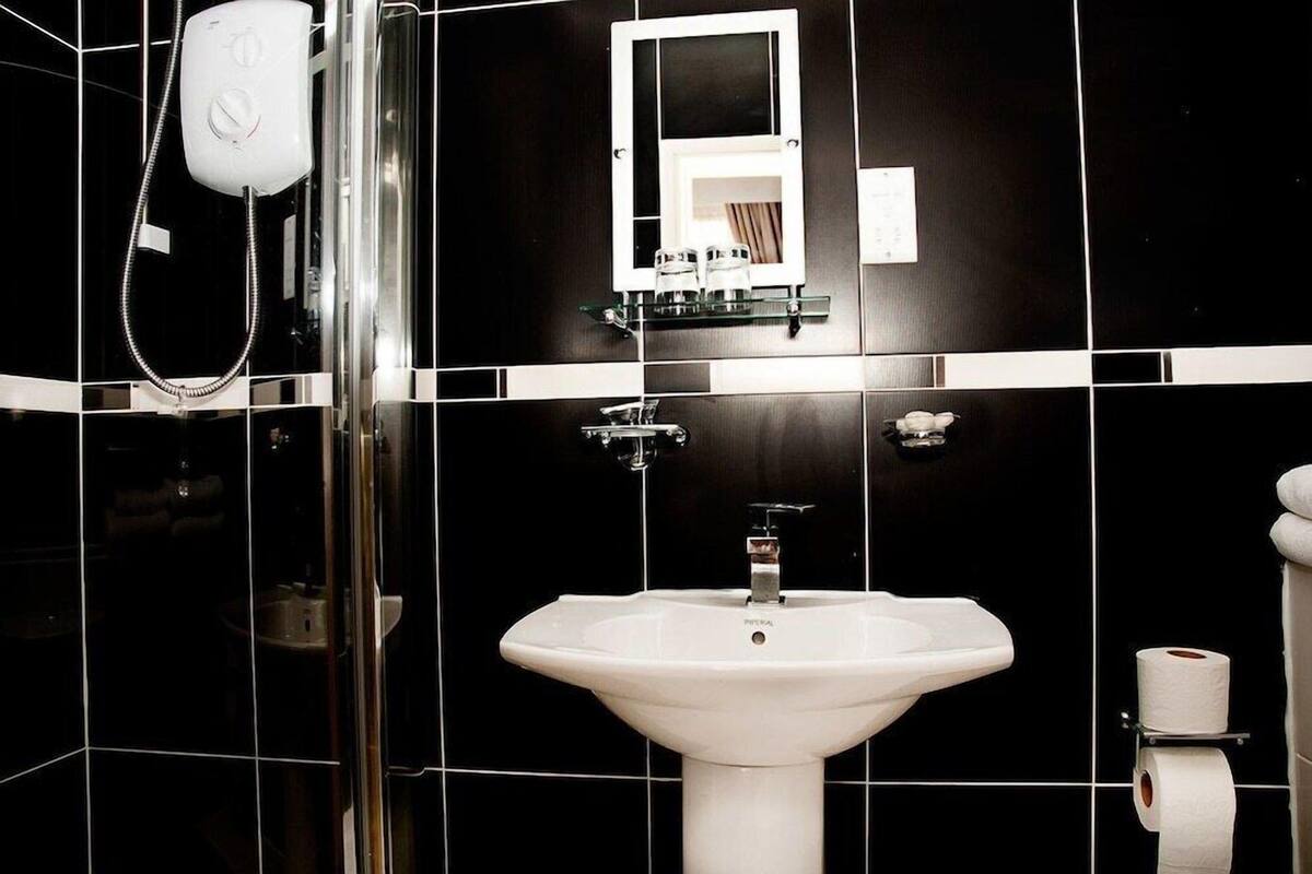 A bathroom with a white sink, a glass shower enclosure, and a white toilet.