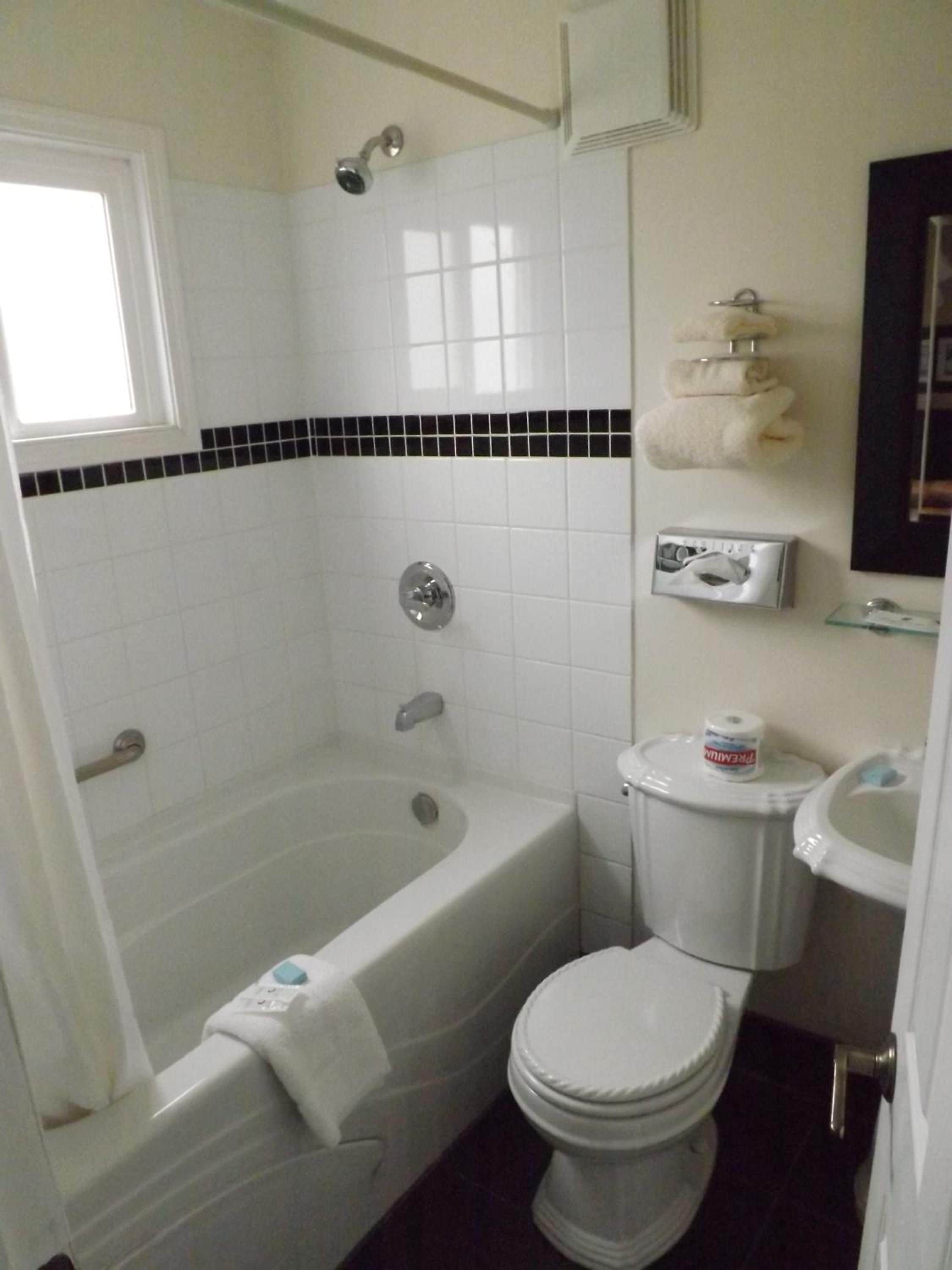 Un baño con bañera, inodoro y ducha.